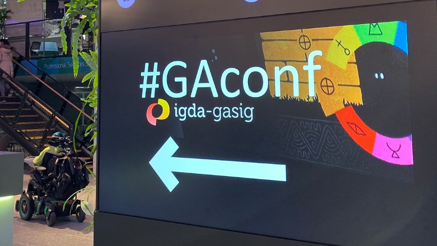 A picture from the GAconference showing its Logo with a person in a wheelchair in the background